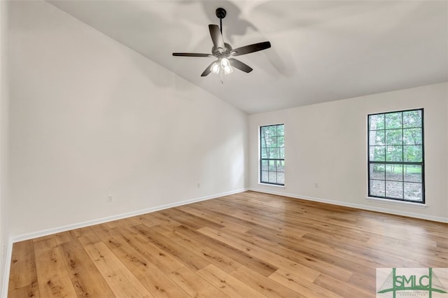 unfurnished room with baseboards, lofted ceiling, ceiling fan, and light wood-style flooring