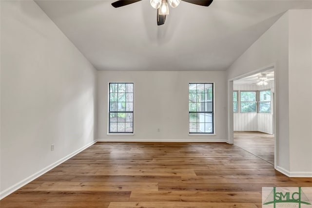 empty room featuring vaulted ceiling, a ceiling fan, and baseboards