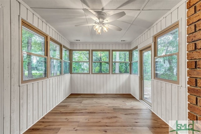 unfurnished sunroom featuring visible vents and ceiling fan