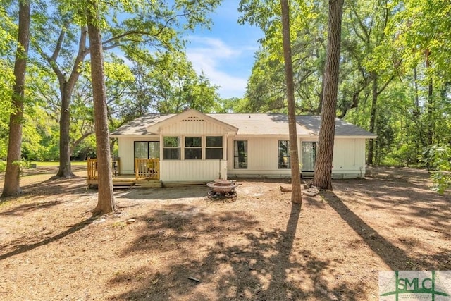 rear view of house featuring a wooden deck and an outdoor fire pit