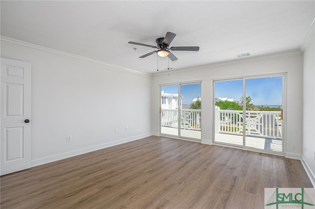 spare room with ceiling fan, baseboards, crown molding, and wood finished floors