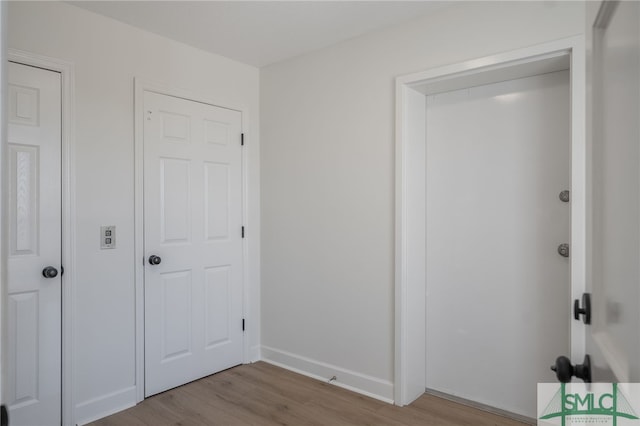 unfurnished bedroom featuring baseboards and wood finished floors