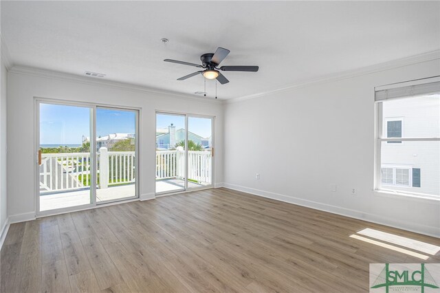 spare room with visible vents, baseboards, and wood finished floors
