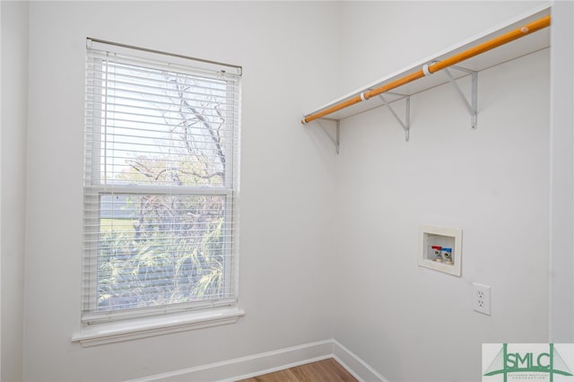 laundry area featuring baseboards, wood finished floors, laundry area, and washer hookup