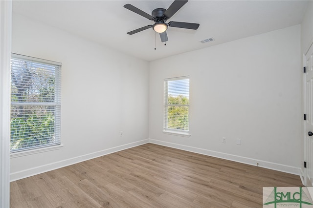 spare room featuring light wood-type flooring, baseboards, a ceiling fan, and visible vents