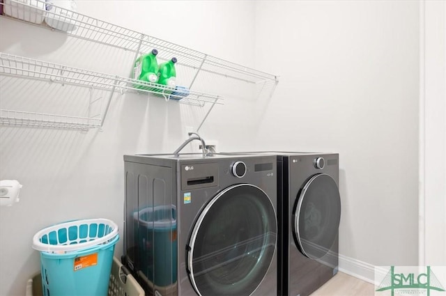 82 Rimmon Ct, Richmond Hill, GA 31324 - washroom with baseboards, wood finished floors, laundry area, and washer and clothes dryer