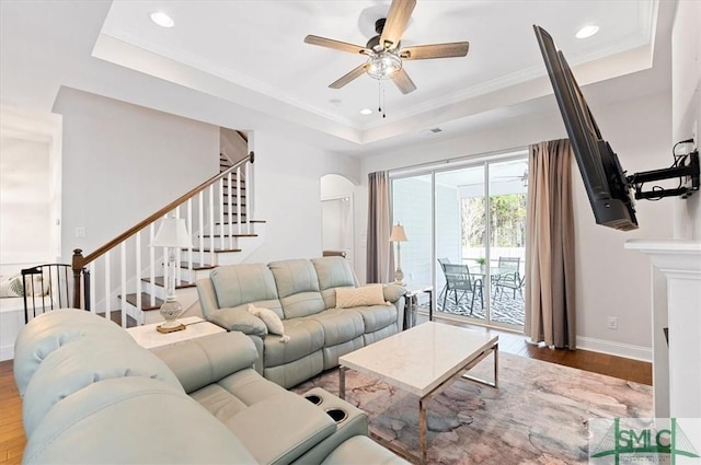82 Rimmon Ct, Richmond Hill, GA 31324 - living area featuring a tray ceiling, stairs, baseboards, a ceiling fan, and wood finished floors