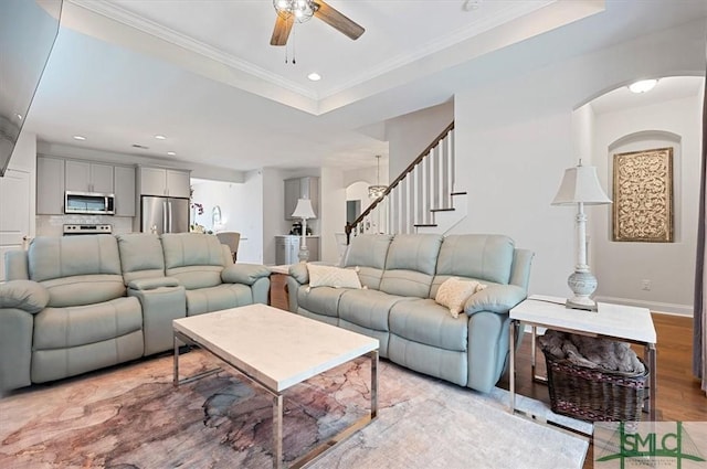 82 Rimmon Ct, Richmond Hill, GA 31324 - living room with crown molding, stairway, a raised ceiling, a ceiling fan, and light wood-style floors