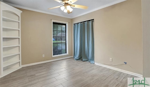 empty room with baseboards, ceiling fan, wood finished floors, and crown molding