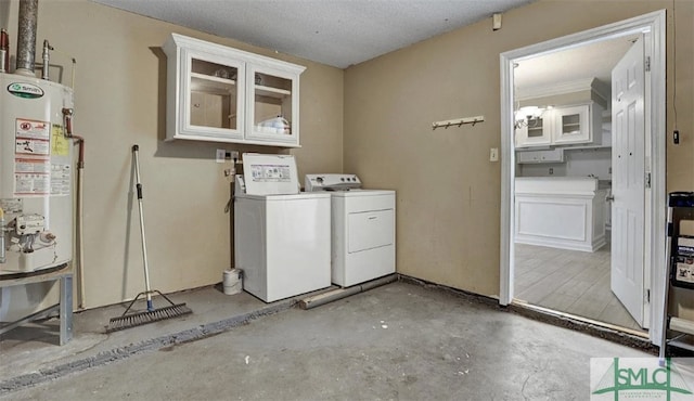 clothes washing area featuring water heater, washing machine and clothes dryer, laundry area, and a textured ceiling