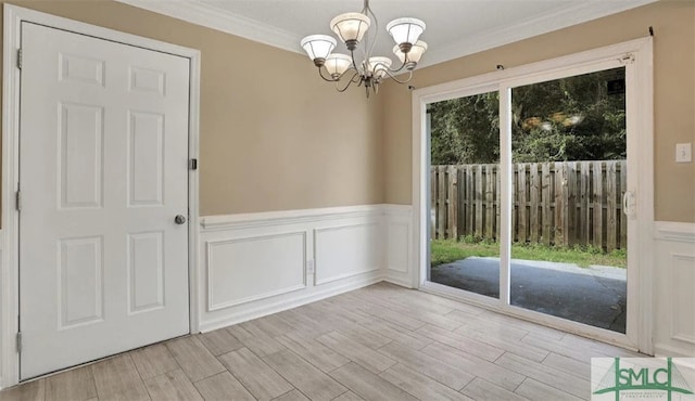 unfurnished dining area with a healthy amount of sunlight, wood tiled floor, crown molding, and an inviting chandelier