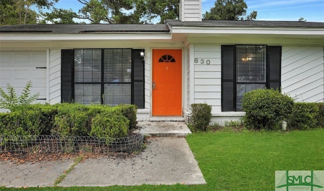 doorway to property with a lawn and a chimney