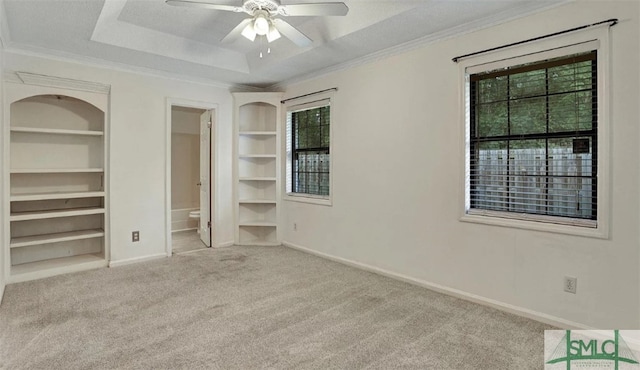 unfurnished bedroom with carpet floors, a raised ceiling, a textured ceiling, baseboards, and ornamental molding