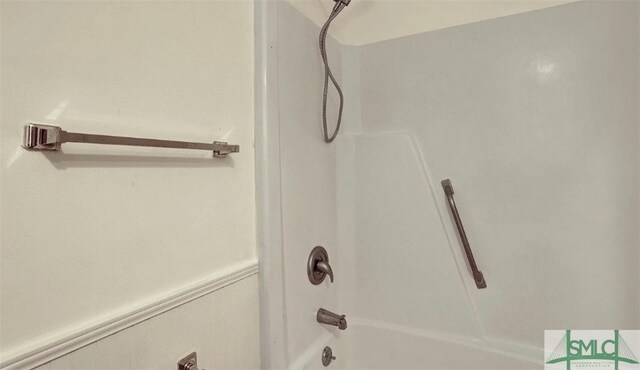 full bath with a wainscoted wall and bathing tub / shower combination