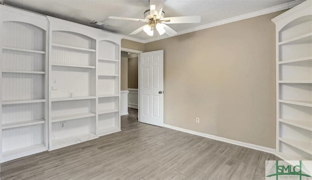 unfurnished bedroom featuring a ceiling fan, ornamental molding, baseboards, and wood finished floors