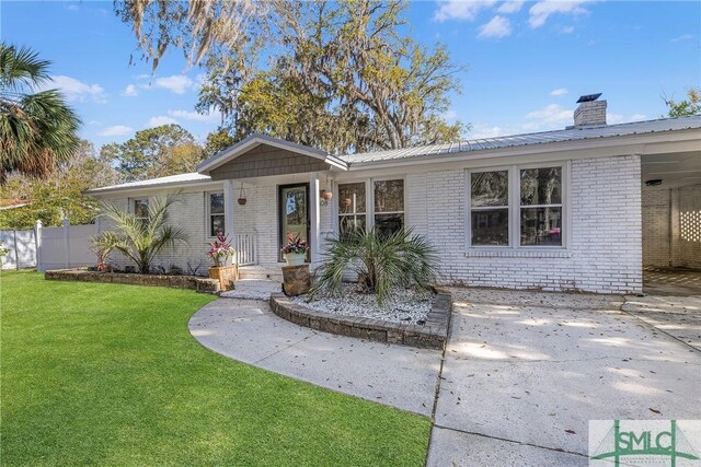 3108 Butler Ave, Savannah, GA 31404 - ranch-style house with metal roof, a front yard, fence, brick siding, and a chimney