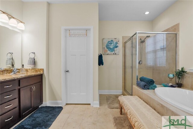 93 Bradford Pear Dr, Richmond Hill, GA 31324 - full bath featuring vanity, a shower stall, a garden tub, tile patterned flooring, and baseboards