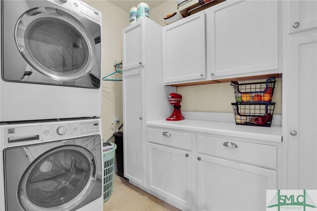 93 Bradford Pear Dr, Richmond Hill, GA 31324 - laundry room featuring stacked washer / dryer, cabinet space, and light tile patterned flooring