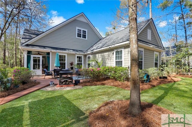 93 Bradford Pear Dr, Richmond Hill, GA 31324 - rear view of house featuring a lawn, ceiling fan, a patio, and roof with shingles