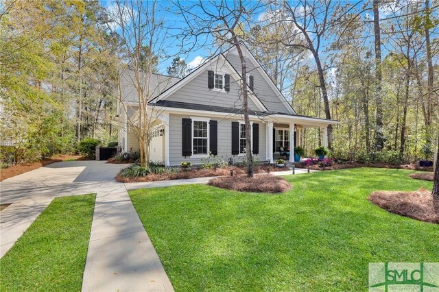 93 Bradford Pear Dr, Richmond Hill, GA 31324 - view of front facade featuring driveway, a front lawn, and a porch