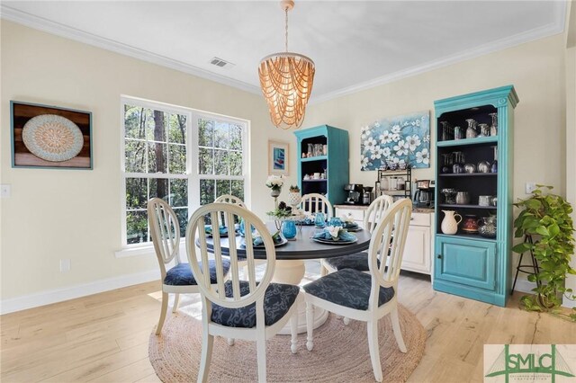 93 Bradford Pear Dr, Richmond Hill, GA 31324 - dining area featuring a chandelier, ornamental molding, light wood-style floors, and baseboards