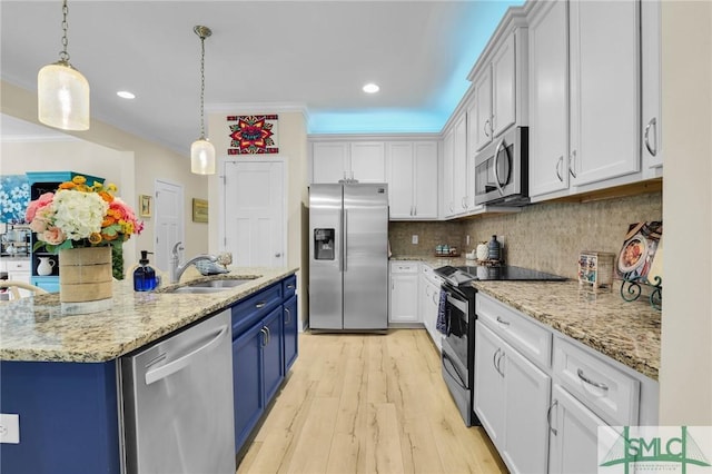 93 Bradford Pear Dr, Richmond Hill, GA 31324 - kitchen featuring stainless steel appliances, a sink, blue cabinets, light wood-style floors, and white cabinets