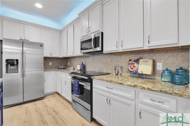 93 Bradford Pear Dr, Richmond Hill, GA 31324 - kitchen with stainless steel appliances, light wood-style floors, light stone countertops, backsplash, and recessed lighting