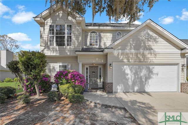 traditional home featuring driveway, an attached garage, and brick siding