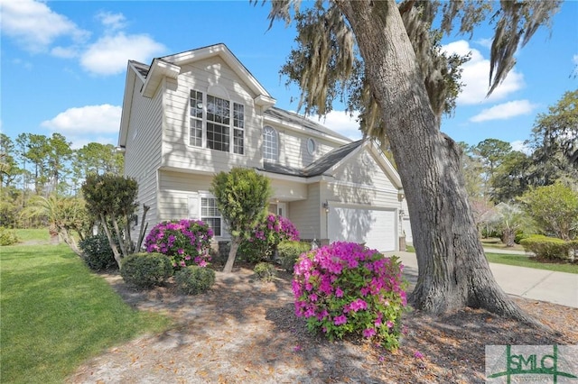 traditional-style home with a front lawn, an attached garage, and concrete driveway