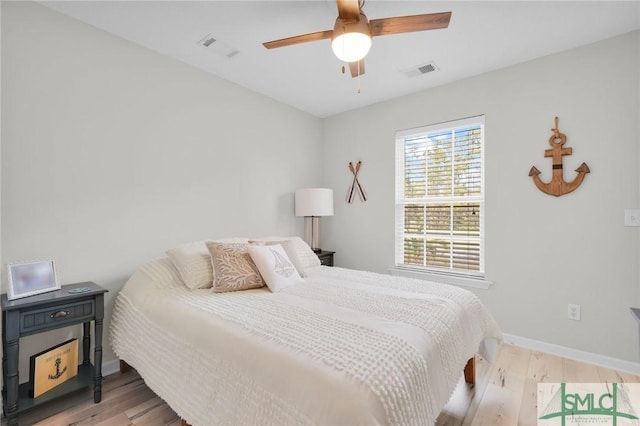 bedroom with wood finished floors, baseboards, ceiling fan, and visible vents