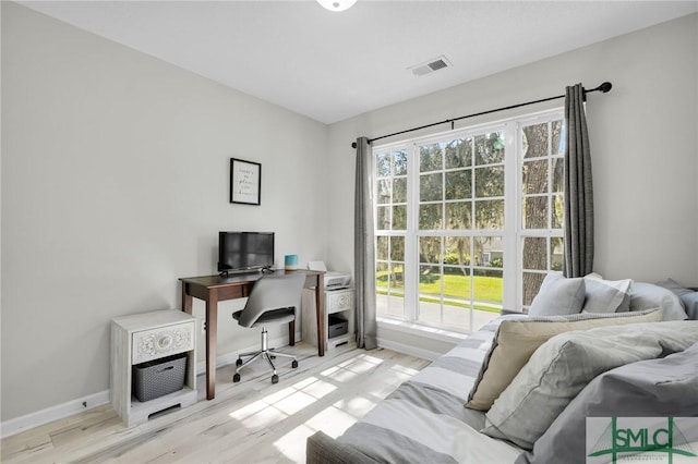 office space with wood finished floors, baseboards, and visible vents