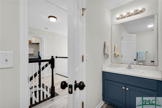 bathroom with baseboards, wood finished floors, and vanity