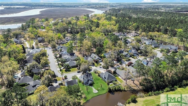 drone / aerial view featuring a residential view, a water view, and a forest view