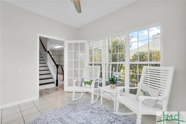 interior space featuring a ceiling fan, tile patterned floors, baseboards, and stairs
