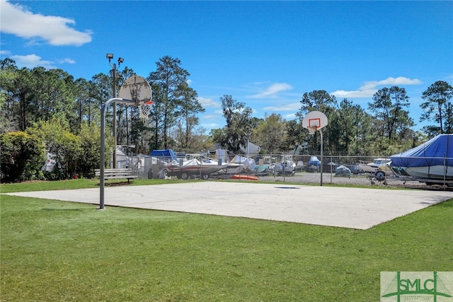 view of sport court with a lawn, community basketball court, and fence