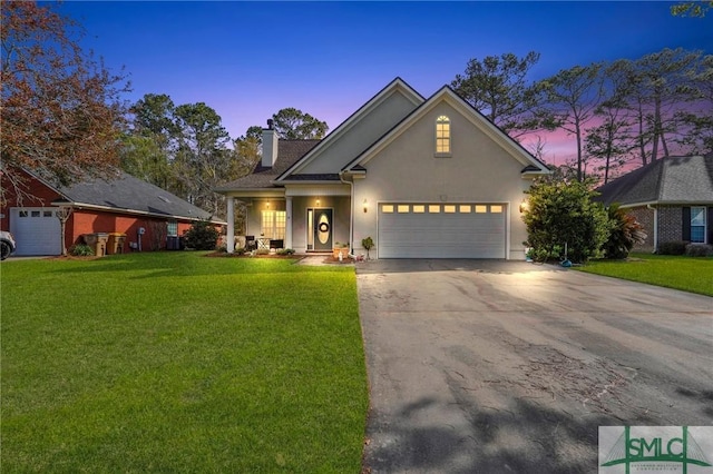 traditional home featuring a front yard, concrete driveway, a chimney, stucco siding, and an attached garage