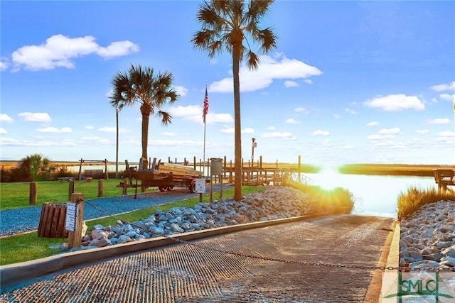 view of home's community featuring a water view and a lawn