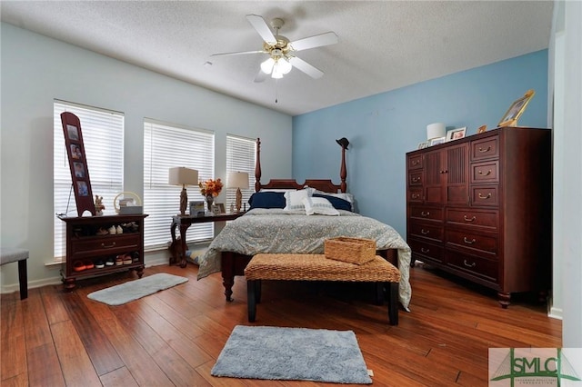 bedroom with ceiling fan, hardwood / wood-style flooring, and a textured ceiling