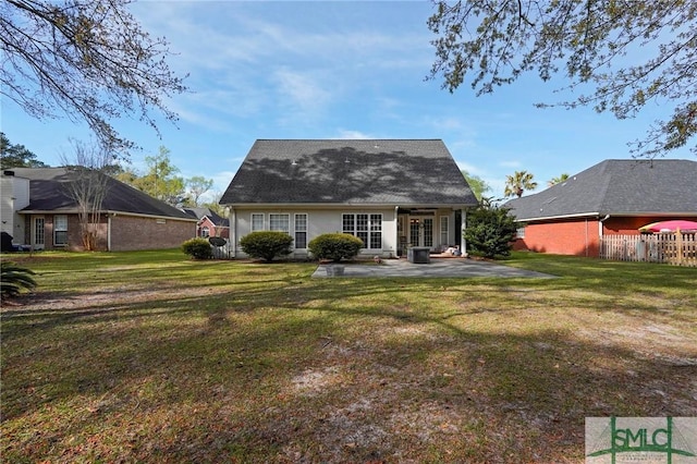 rear view of house with fence, a lawn, and a patio area