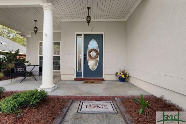 property entrance featuring stucco siding and covered porch