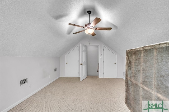additional living space featuring a textured ceiling, a ceiling fan, carpet flooring, lofted ceiling, and baseboards