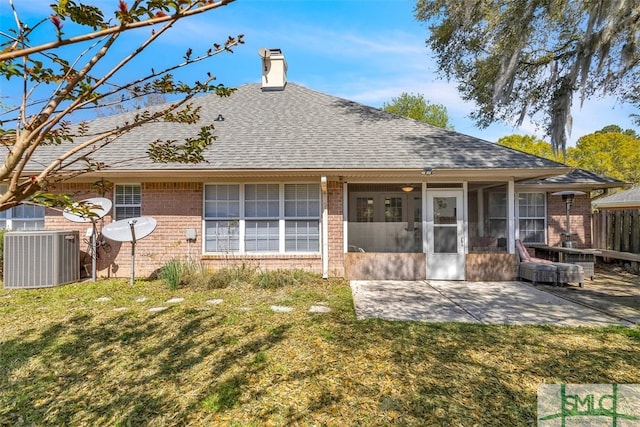 rear view of property with brick siding, central AC unit, roof with shingles, and a chimney