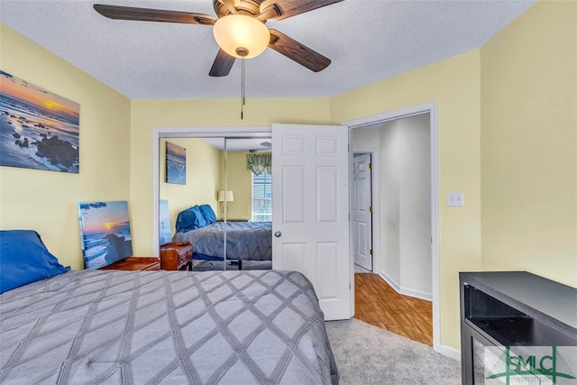 bedroom featuring carpet floors, a closet, a textured ceiling, and ceiling fan