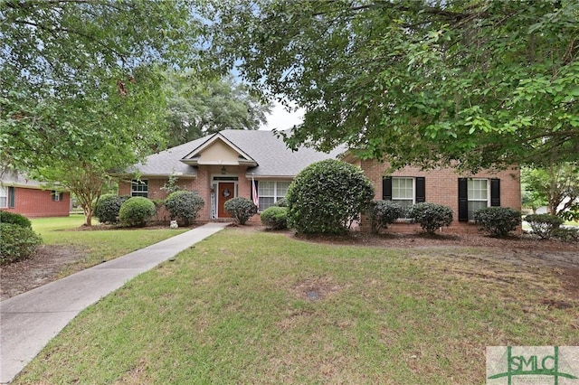 view of front of house featuring brick siding and a front yard
