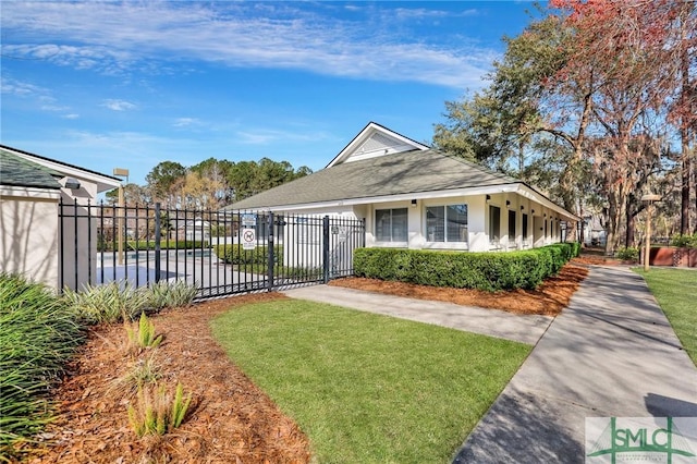 view of front facade featuring fence, a gate, stucco siding, and a shingled roof