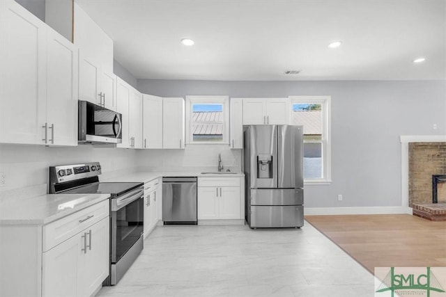 kitchen featuring a healthy amount of sunlight, light countertops, a sink, and stainless steel appliances