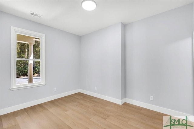 spare room featuring baseboards, light wood-style floors, and visible vents