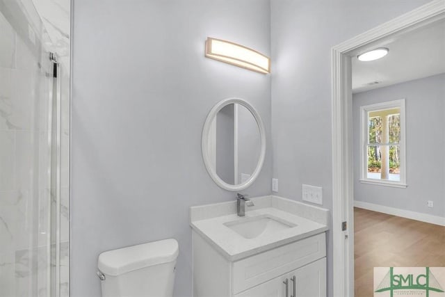 bathroom with toilet, vanity, wood finished floors, walk in shower, and baseboards