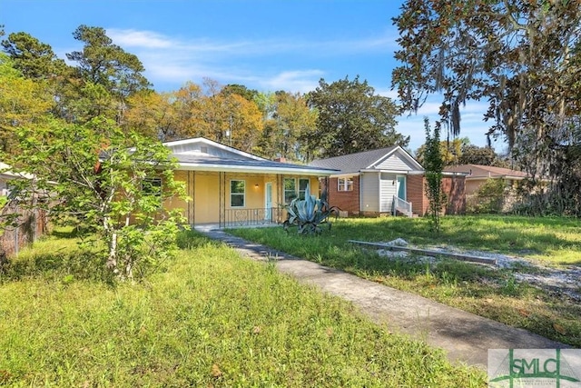 ranch-style house featuring covered porch and a front yard