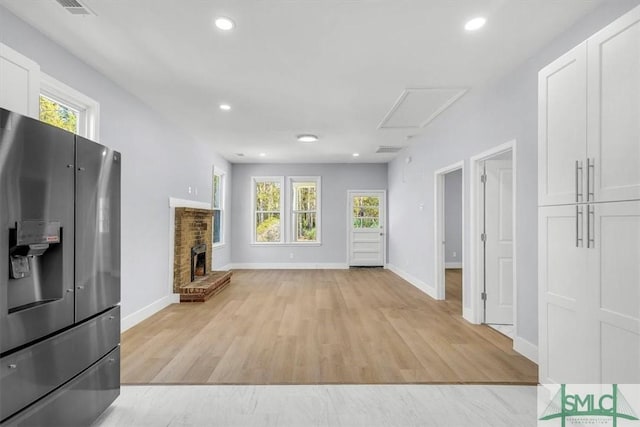 unfurnished living room with a fireplace, recessed lighting, light wood-style floors, and plenty of natural light